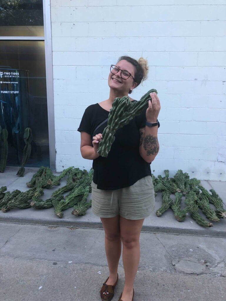 Leah Van Namen holding a cactus while standing outside