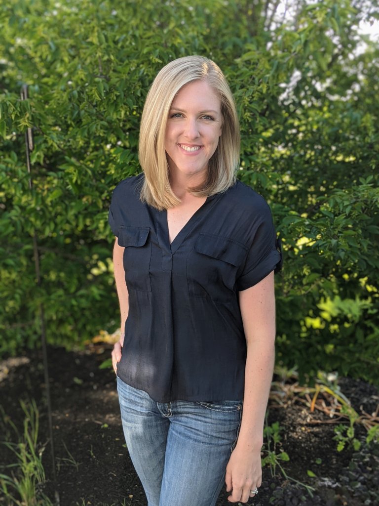 Lindsay Pangborn standing in front of foliage 
