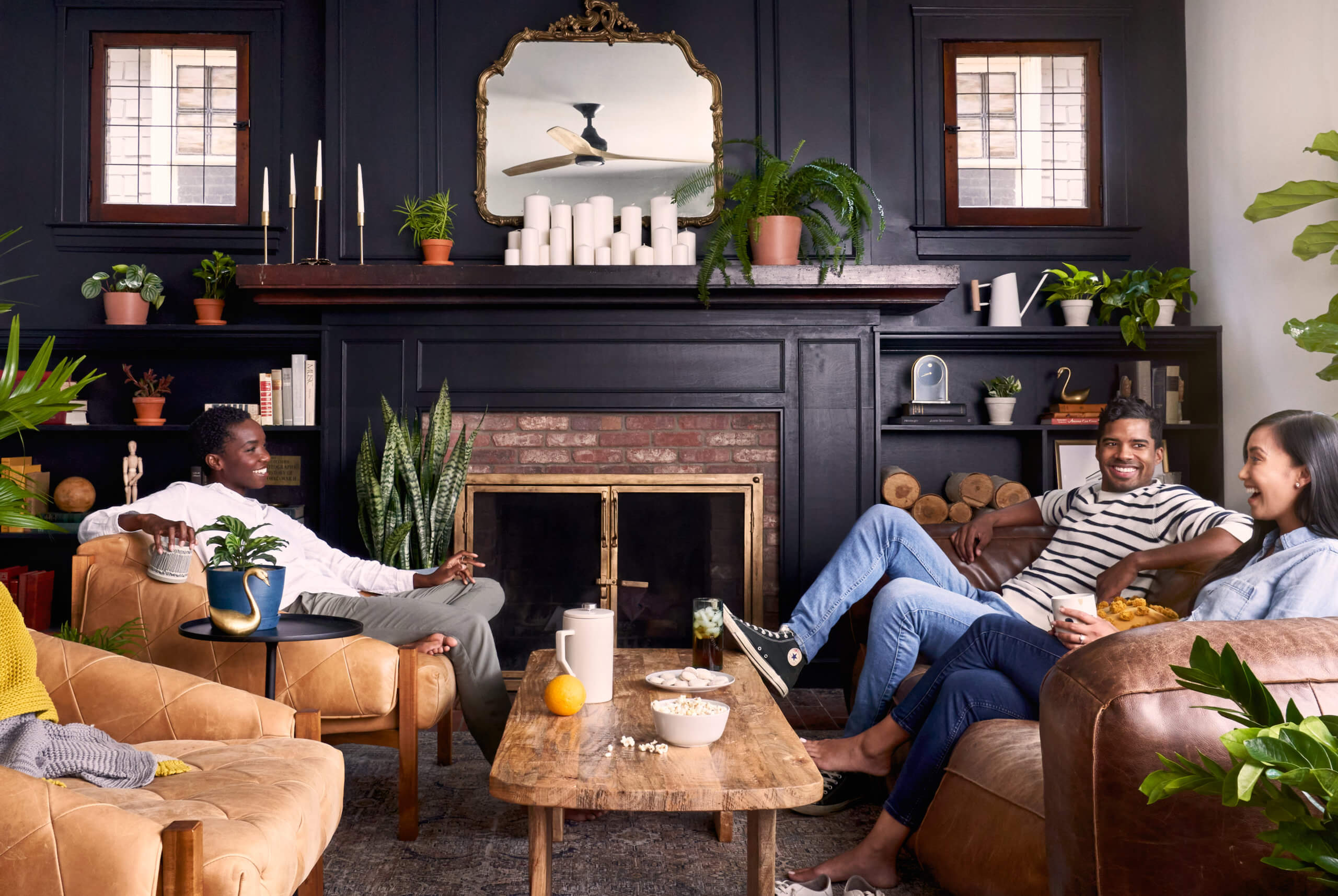 Three people sitting in a living room surrounded by Bloomscape plants