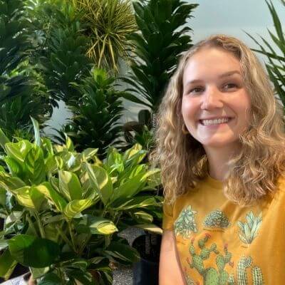 Woman standing next to Bloomscape plants