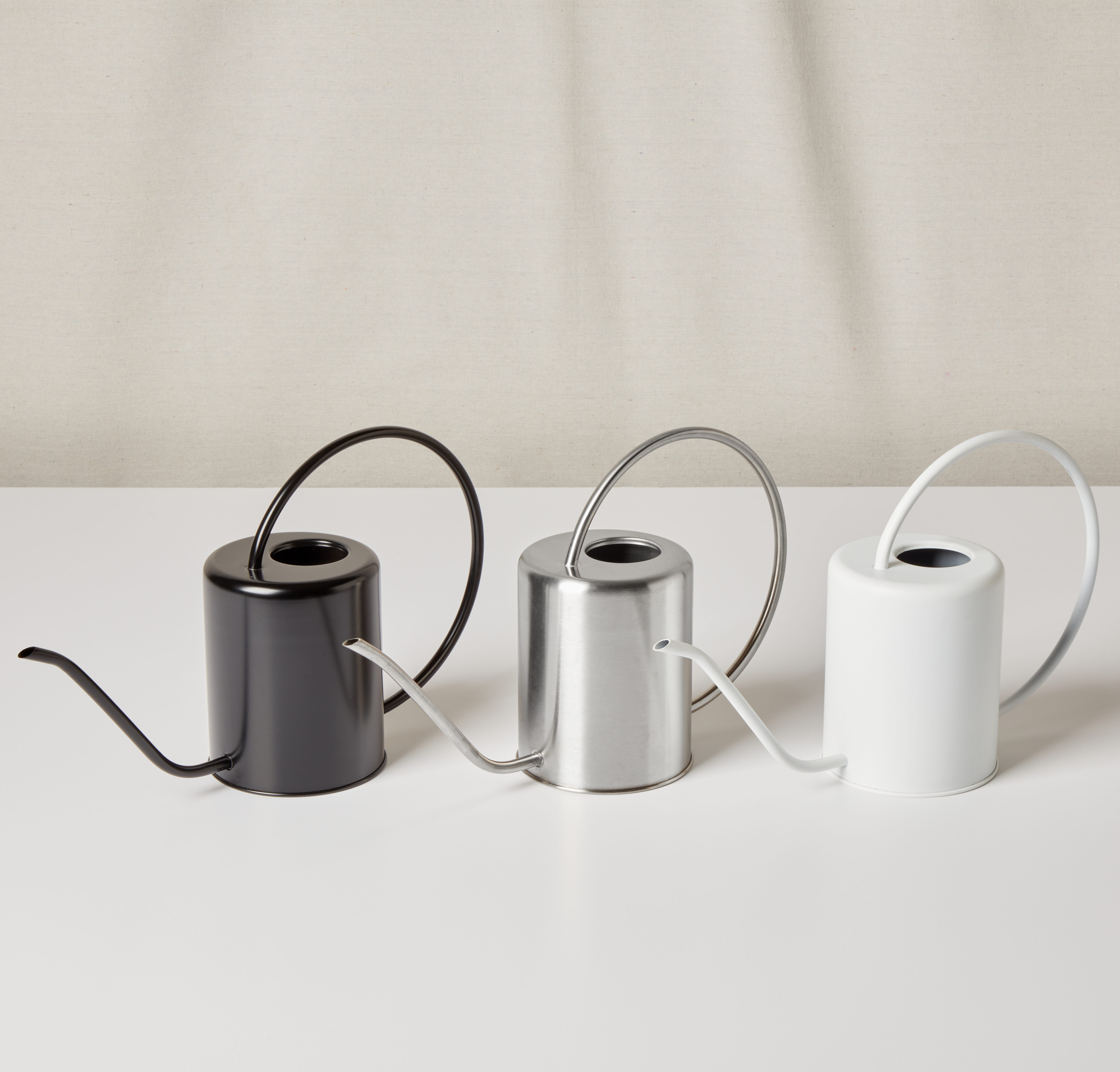 group of black, silver, and white watering cans